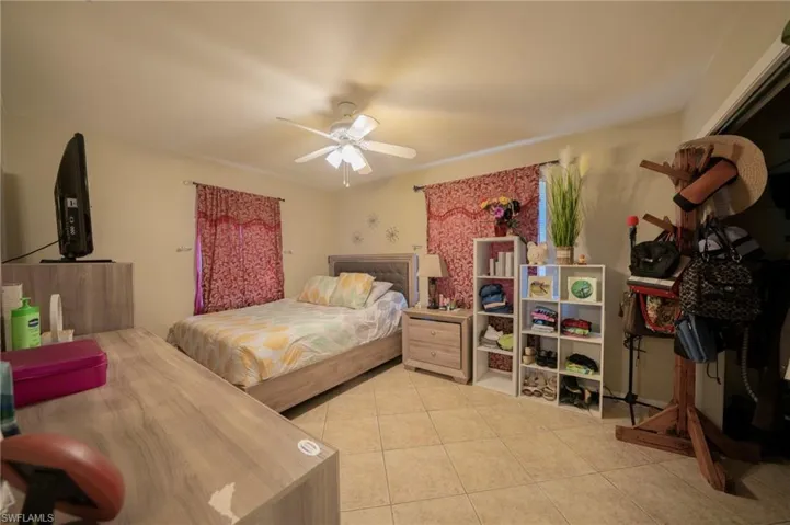 Bedroom featuring light tile patterned floors and ceiling fan