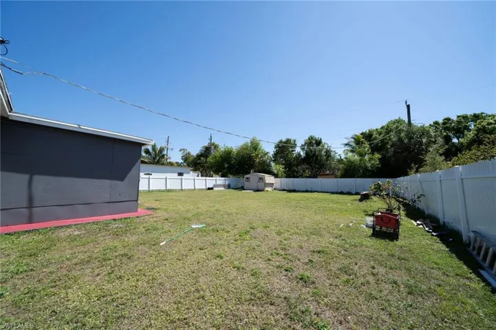 View of yard with an outdoor structure, a fenced backyard, and a shed