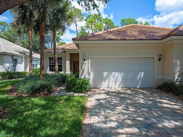 Single story home with a 2020 tiled roof, a garage, stucco siding, and decorative driveway
