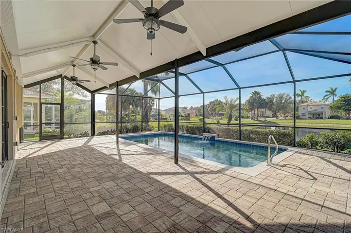 View of pool with ceiling fan, a lanai, pool water feature, and a patio area