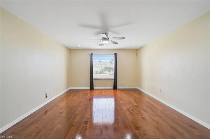 Unfurnished room featuring ceiling fan and wood-type flooring