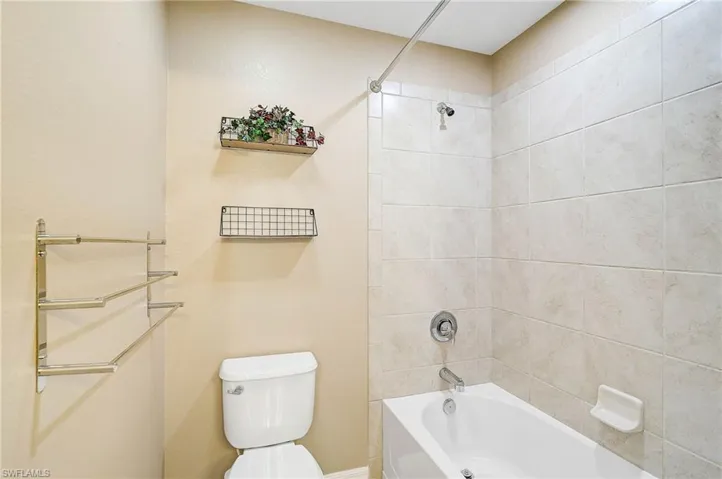 Bathroom featuring toilet and tiled shower / bath combo