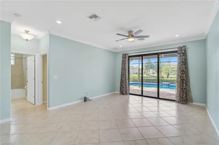 Unfurnished family room featuring ceiling fan, light tile patterned floors, and crown molding