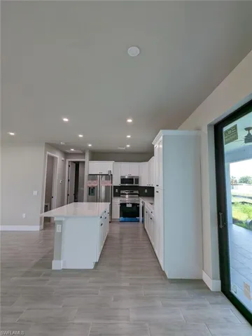 Kitchen featuring white cabinetry, stainless steel appliances, and a kitchen island