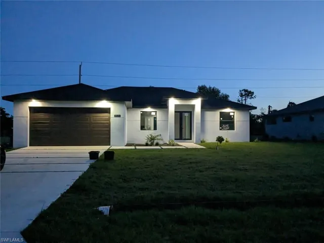 View of front facade with a garage and a front lawn
