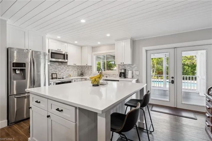 Kitchen with white cabinetry, a center island, stainless steel appliances, and french doors