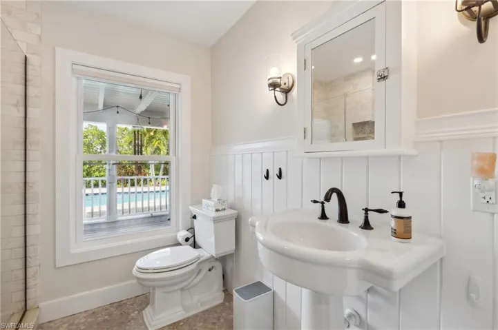 Bathroom featuring tiled shower and toilet