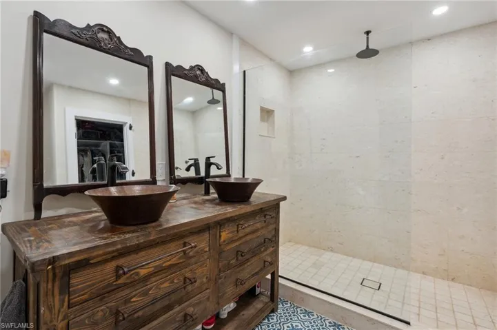 Bathroom featuring a tile shower and vanity