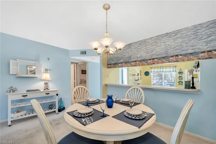 Carpeted dining space featuring suspended lighting and baseboards