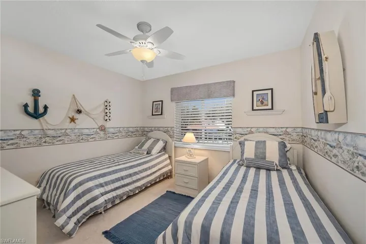 Bedroom with light carpet and a ceiling fan