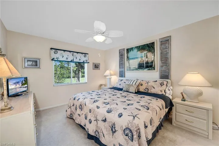 Bedroom with light colored carpet and a ceiling fan