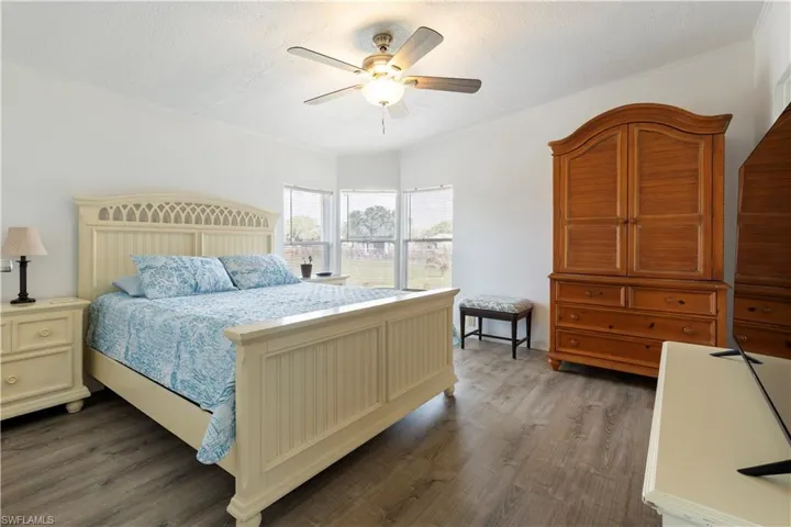 Bedroom featuring dark wood finished floors, a ceiling fan, and a textured ceiling