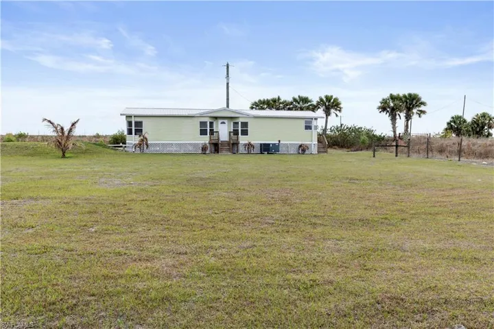 Back of property featuring a lawn