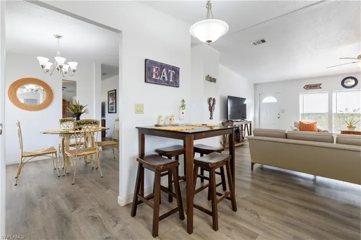Dining space featuring wood finished floors, a textured ceiling, suspended lighting, and ceiling fan