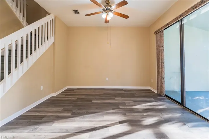 Empty room with a ceiling fan and dark wood-type flooring
