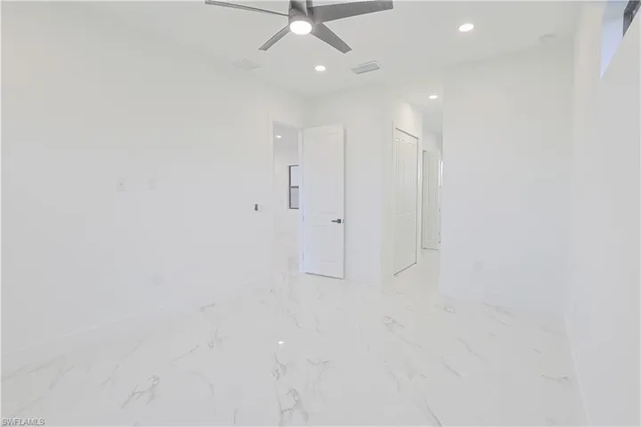 Spare room featuring a ceiling fan, recessed lighting, and light marble finish floors