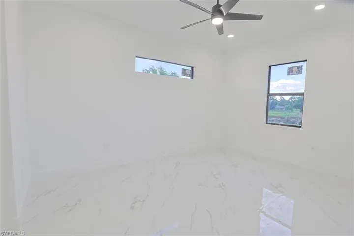 Spare room with recessed lighting, marble look tiles, and ceiling fan