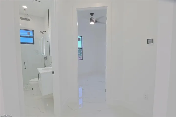 Corridor with light marble finish flooring and plenty of natural light