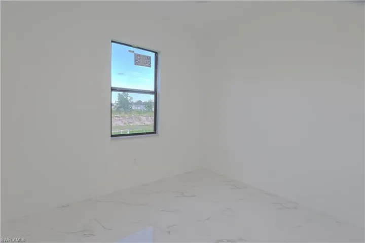 Unfurnished room featuring baseboards and marble look tiles