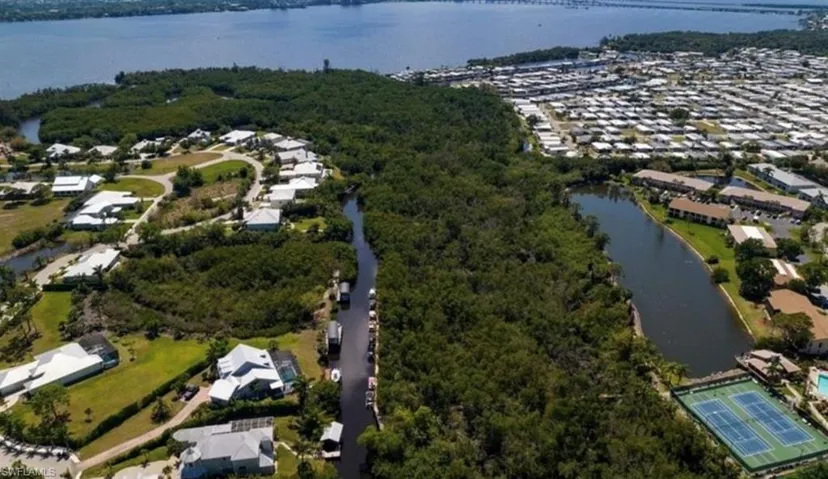 Aerial overview of property's location featuring a nearby body of water and nearby suburban area
