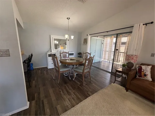 Dining room featuring dark wood-type flooring and hanging lights