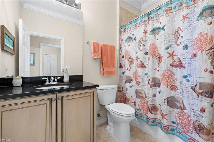 The guest bathroom with a tub/shower combo & lovely granite counter