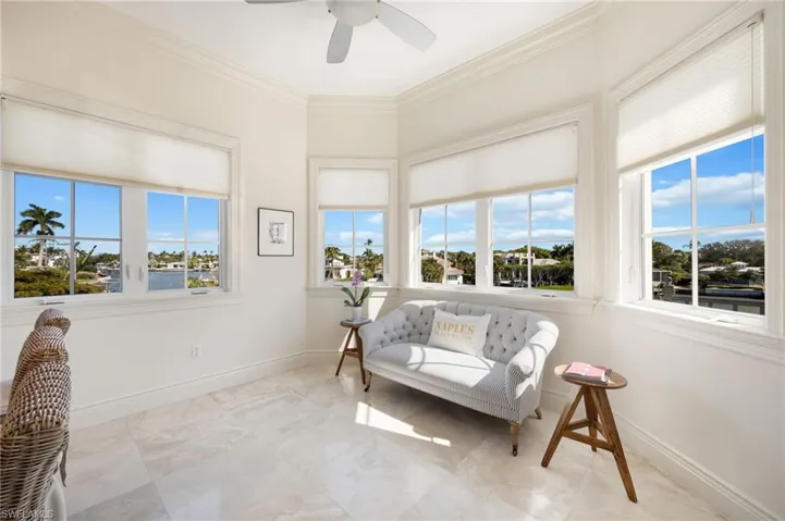 Living area featuring healthy amount of natural light, ornamental molding, and ceiling fan