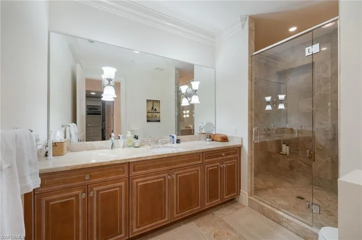 Bathroom with crown molding, vanity, a shower stall, recessed lighting, and light tile patterned flooring