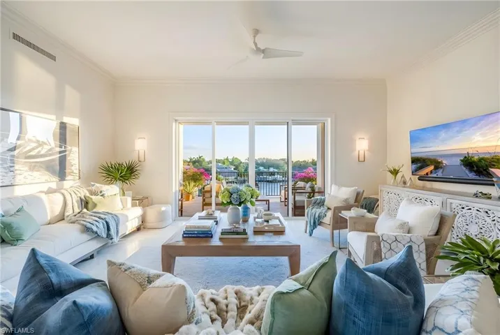 Living area featuring a ceiling fan and ornamental molding