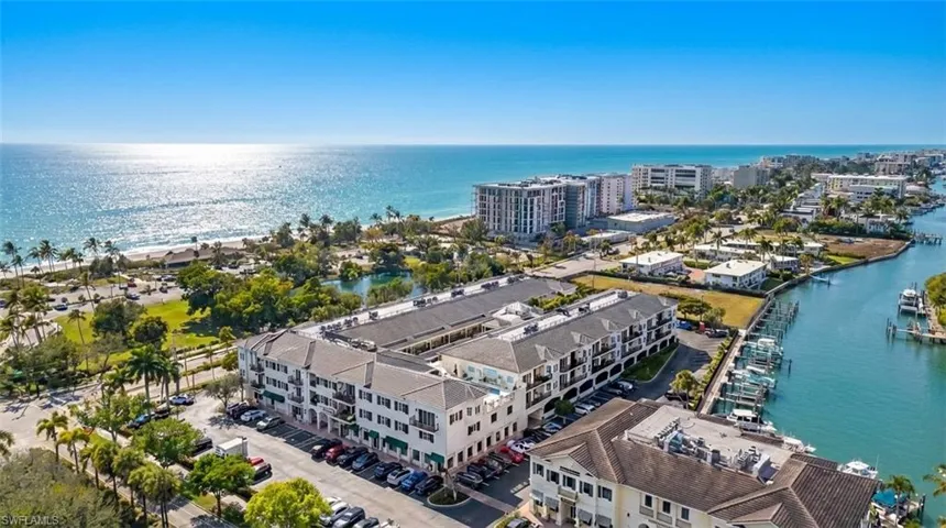 Drone / aerial view of a large body of water and apartment complex / building