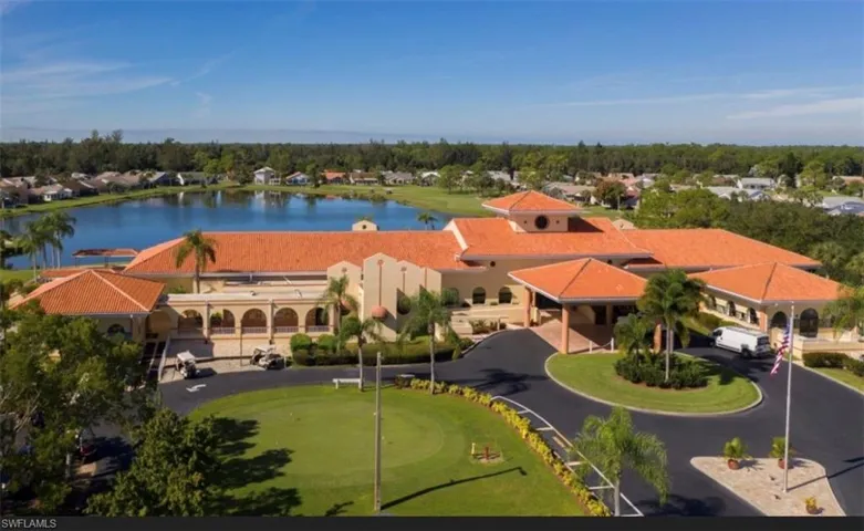 Clubhouse structure featuring a tile roof, arched windows, and a circular driveway