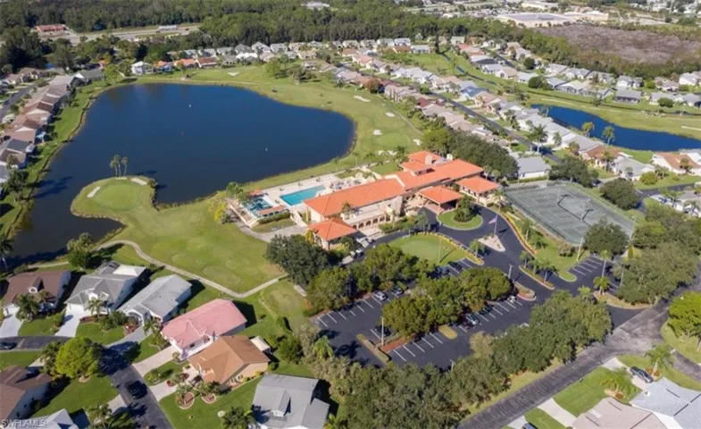 Aerial perspective showcasing a residential community with a large central pond