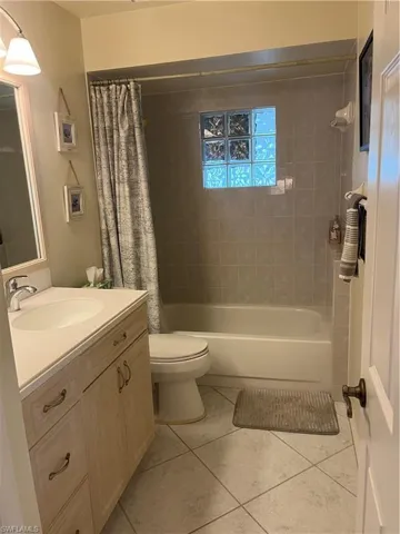 Bathroom featuring a single vanity with light-toned cabinetry, an integrated sink, and a chrome faucet