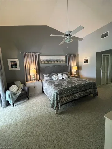 Vaulted ceilings with a ceiling fan overhead, paired with soft carpeting underfoot