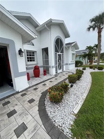 Exterior featuring a decorative arched entry with a security screen door, complemented by an accent window and a decorative outdoor light fixture