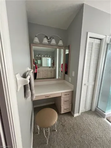 Built-in vanity area featuring a light-toned countertop, mirrored backsplash, and integrated storage drawers