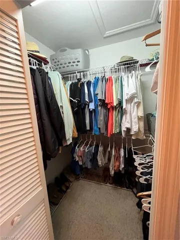 Walk-in closet featuring louvered bi-fold doors, white wire shelving, and light-colored flooring