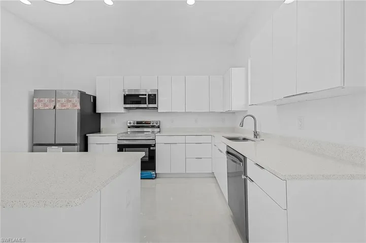 Kitchen with a sink, white cabinets, modern cabinets, and stainless steel appliances