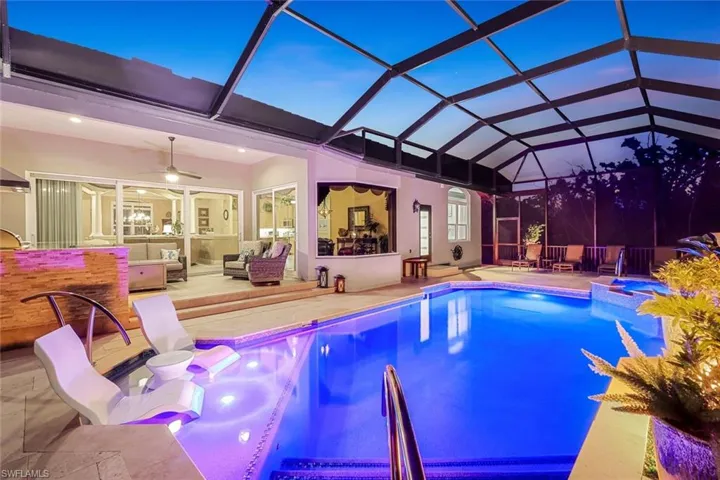 Marble surround, high tech wifi LED lighting and swim ledge elevate this outdoor pool lanai