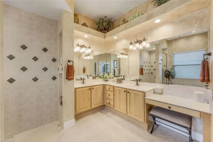 Spacious master bath featuring dual sinks, custom cabinets and mirrors, tile flooring, fully automated top of the line toto in water closet.