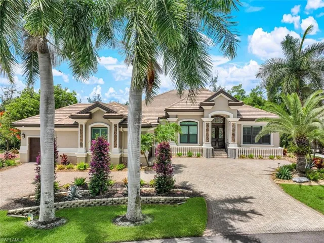 Mediterranean / spanish home with circle drive and side load garage.