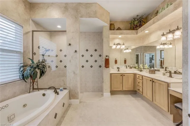 Bathroom with shower with separate jetted tub, tile flooring, and double vanity