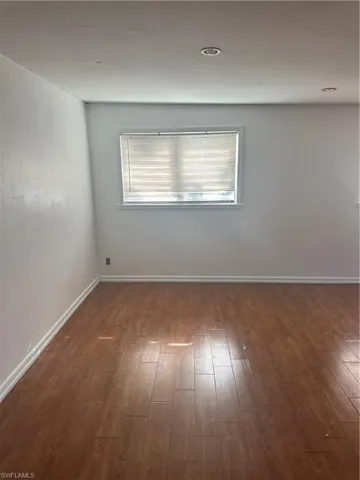 Empty room featuring hardwood / wood-style floors and baseboards