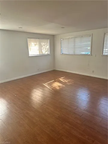 Unfurnished room with hardwood / wood-style floors and baseboards