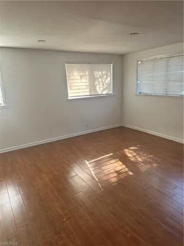 Spare room with hardwood / wood-style floors and baseboards