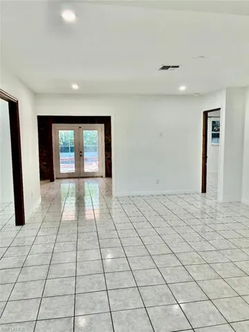 Empty room featuring french doors, recessed lighting, and light tile patterned flooring