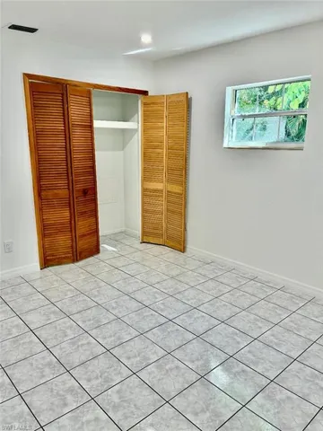 Unfurnished bedroom with a closet and light tile patterned floors