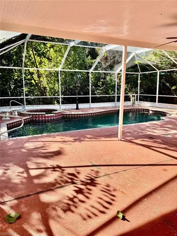 View of swimming pool with a lanai, a sunroom, a patio, and a pool with connected hot tub