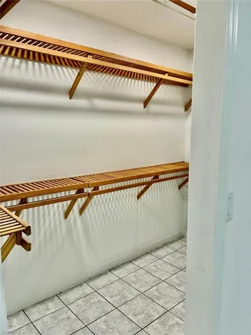 Spacious closet with light tile patterned floors