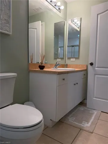 Half bathroom with vanity and light tile patterned flooring